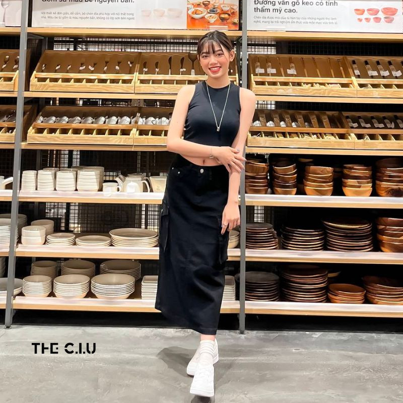 Cô gái mặc áo croptop 3 lỗ màu trắng đơn giản nhưng tôn dáng, kết hợp cùng quần jean tạo phong cách năng động và quyến rũ