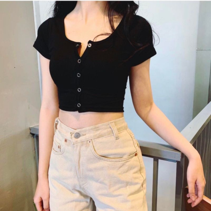 Cô gái mặc áo croptop ôm màu trắng be, tôn dáng thon gọn, phù hợp cho vẻ ngoài thanh lịch và hiện đại