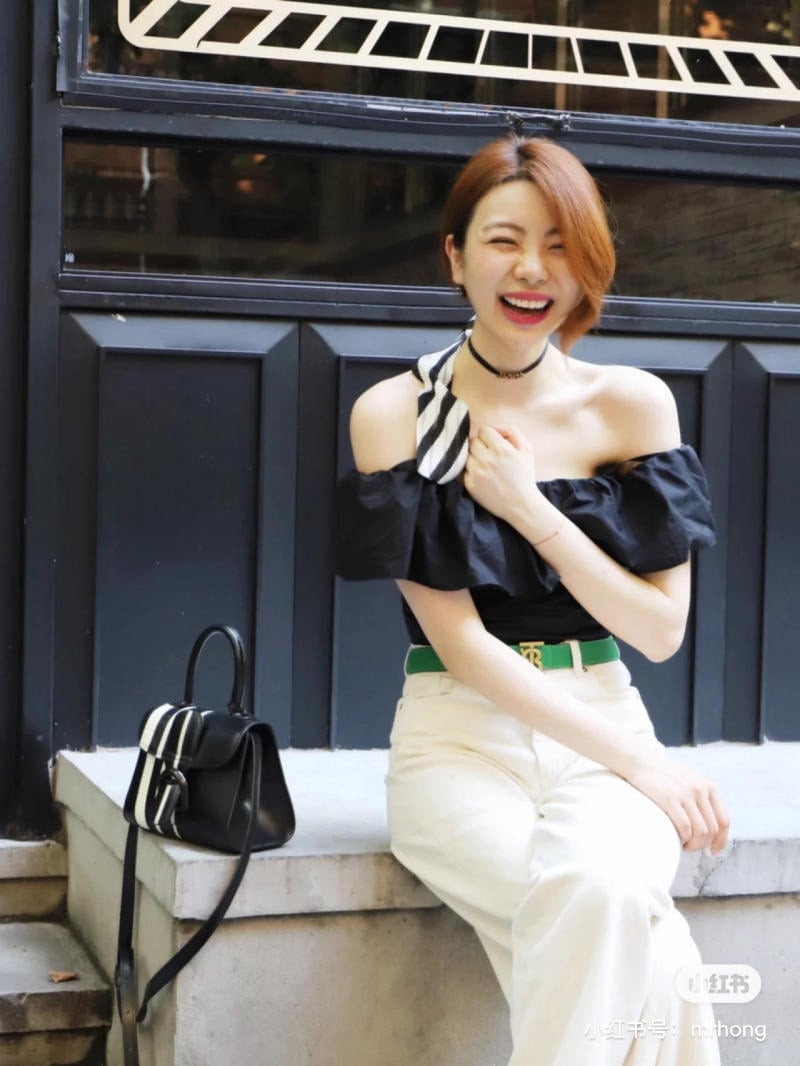 Mẫu áo trễ vai croptop và quần jean trắng, kết hợp phụ kiện tóc và túi xách họa tiết