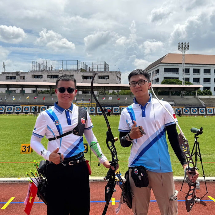 Áo polo đồng phục bắn cung với màu trắng chủ đạo kết hợp xanh, thiết kế tinh tế cho vận động viên.