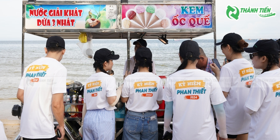 Áo thun đồng phục team building doanh nghiệp màu cam nổi bật, với logo công ty in lớn ở mặt trước, thể hiện tinh thần đồng đội