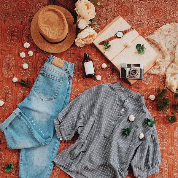 Bộ trang phục và phụ kiện được bố trí flatlay trên background vân gỗ, tạo nên một bối cảnh chụp hình quần áo sáng tạo.