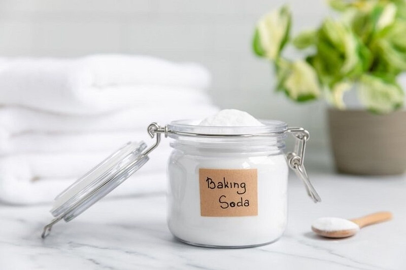 Bột baking soda trắng tinh khiết trong chén nhỏ, một nguyên liệu tự nhiên đa năng được dùng để làm sạch và cải thiện độ sáng màu cho quần áo phai.