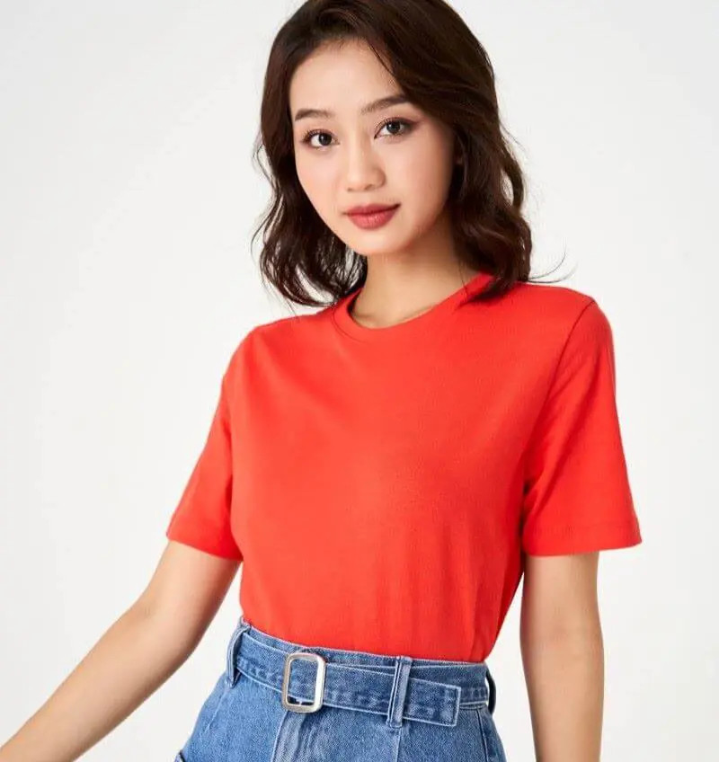 Cô gái trẻ năng động mặc áo thun đỏ với quần jeans, thể hiện sự cá tính và sức hút của trang phục áo đỏ.