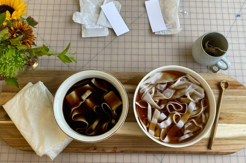 Hạt cà phê rang xay và lá trà đen khô, hai nguyên liệu tự nhiên giàu tannin, giúp nhuộm và phục hồi màu sắc cho quần áo tối màu hiệu quả.