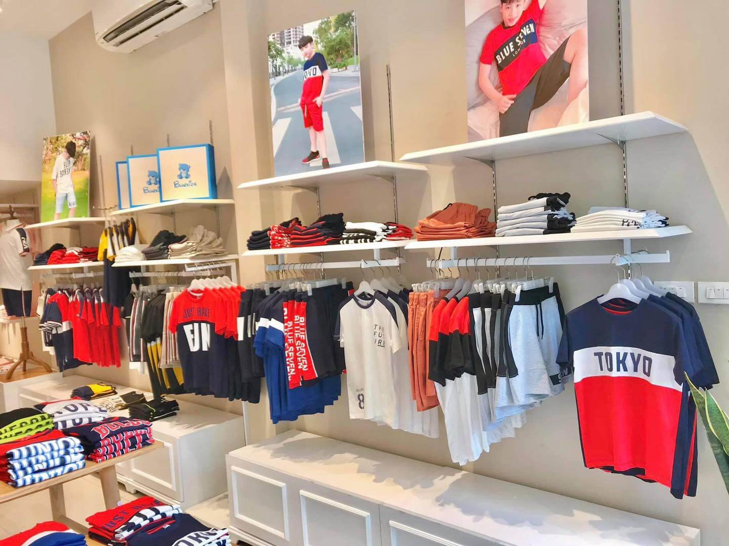 Mẫu shop quần áo trẻ em với thiết kế hiện đại, gam màu trắng chủ đạo và điểm nhấn khinh khí cầu
