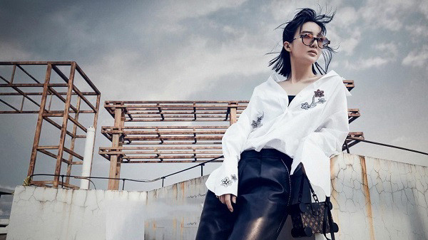 Người mẫu tạo dáng chuyên nghiệp với trang phục, làm nổi bật sản phẩm trên một background studio tối giản.