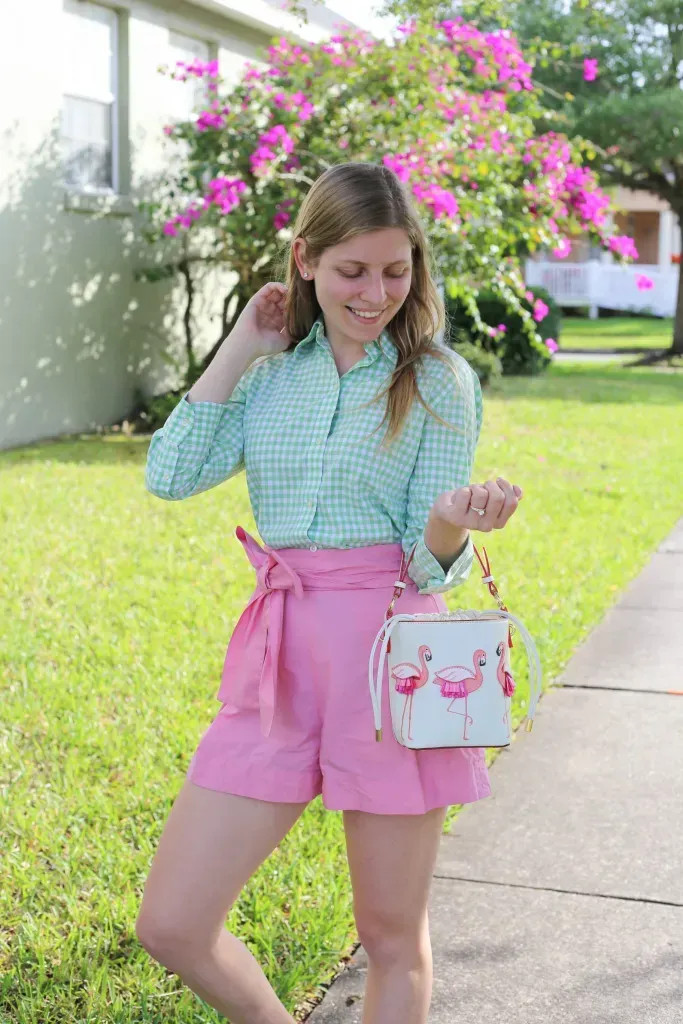 Quần tây ống đứng màu hồng san hô kết hợp áo sơ mi xanh lam nhạt, tạo vẻ ngoài trẻ trung, tươi sáng và đầy phong cách.