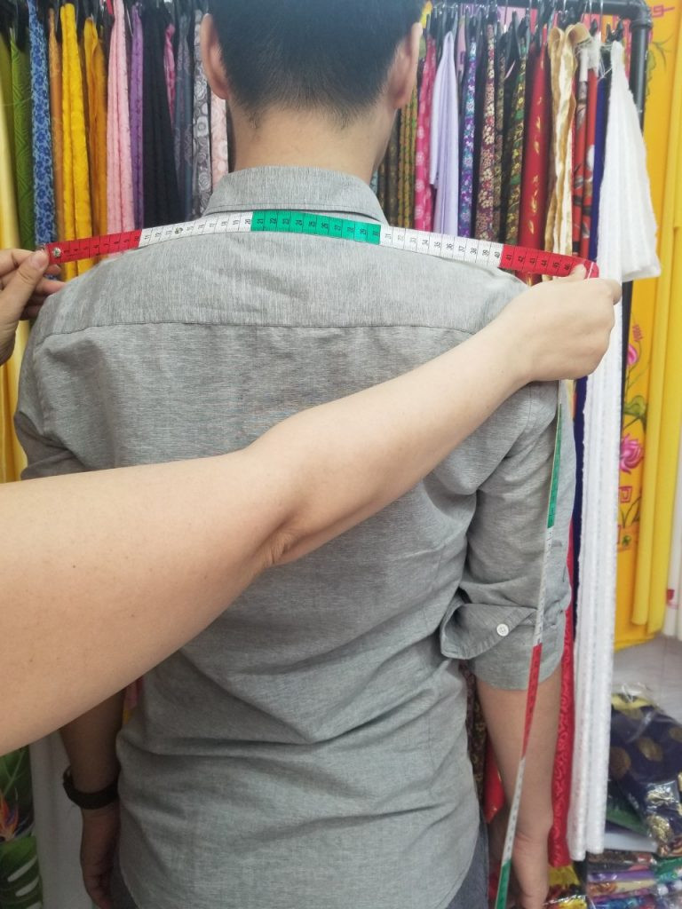 Áo dài đỏ quần xanh cổ vịt nổi bật với họa tiết thêu tinh xảo, thể hiện sự sang trọng và hiện đại