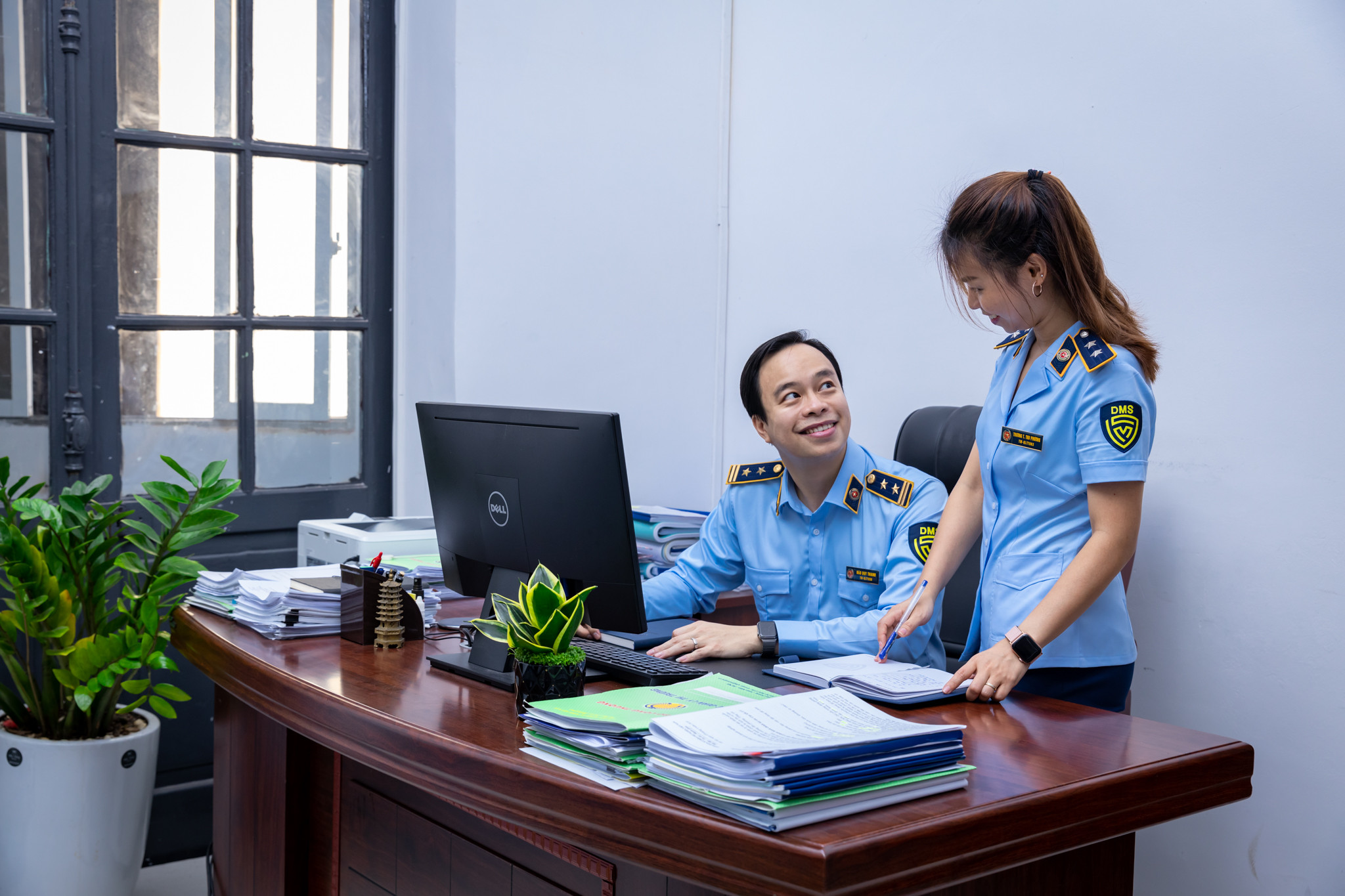 Cán bộ quản lý thị trường mặc áo ngành đang bắt tay với người dân, thể hiện sự hợp tác và giao tiếp cộng đồng