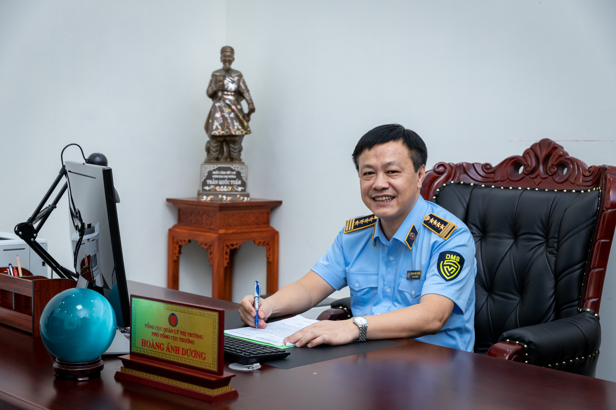 Cán bộ quản lý thị trường trong trang phục ngành nhận hoa, biểu tượng cho sự ghi nhận đóng góp của lực lượng