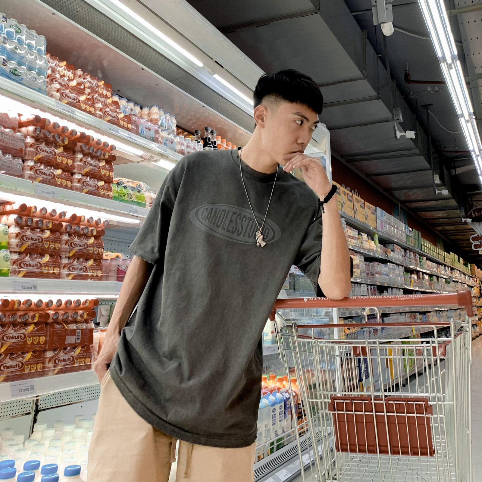 Chàng trai mặc áo thun xám với quần short nâu nhạt, tạo vẻ ngoài trẻ trung, tươi mới và thoải mái.