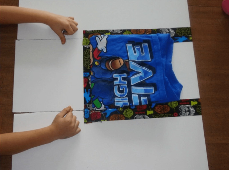 Chiếc áo đã được gấp gọn gàng và ngăn nắp nhờ dụng cụ bìa carton tự làm