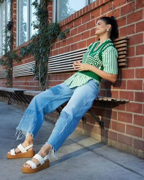 Cô gái mặc áo croptop sọc ngang, quần kaki ống rộng màu kem và giày đế xuồng thoải mái, phù hợp cho mùa hè