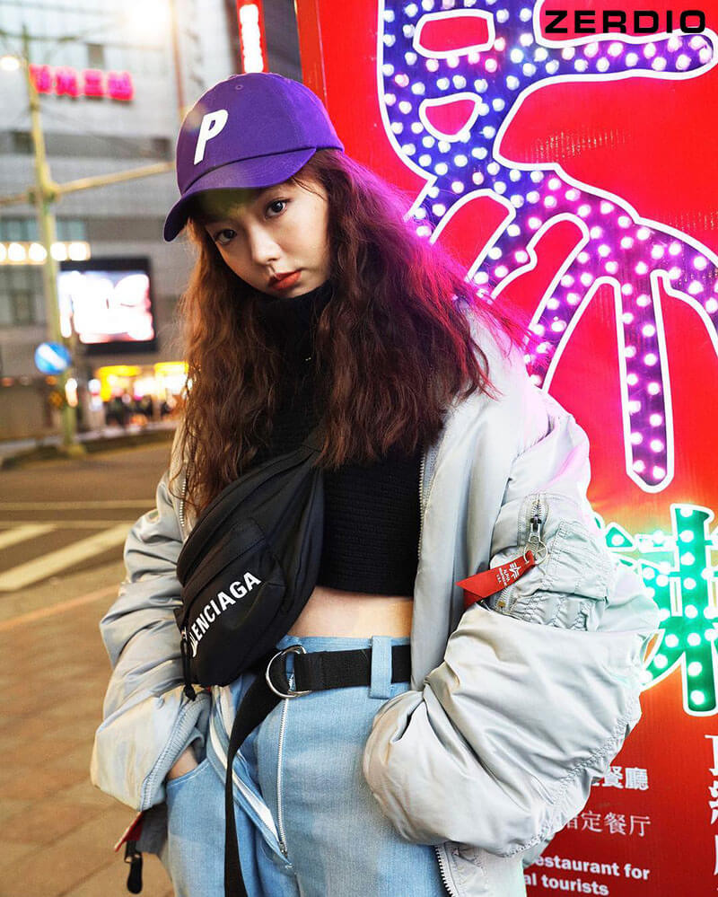 Cô gái tạo dáng với quần baggy jeans và áo thun bó sát màu trắng, kết hợp sneaker trắng, tạo nên outfit hiphop nữ trẻ trung.