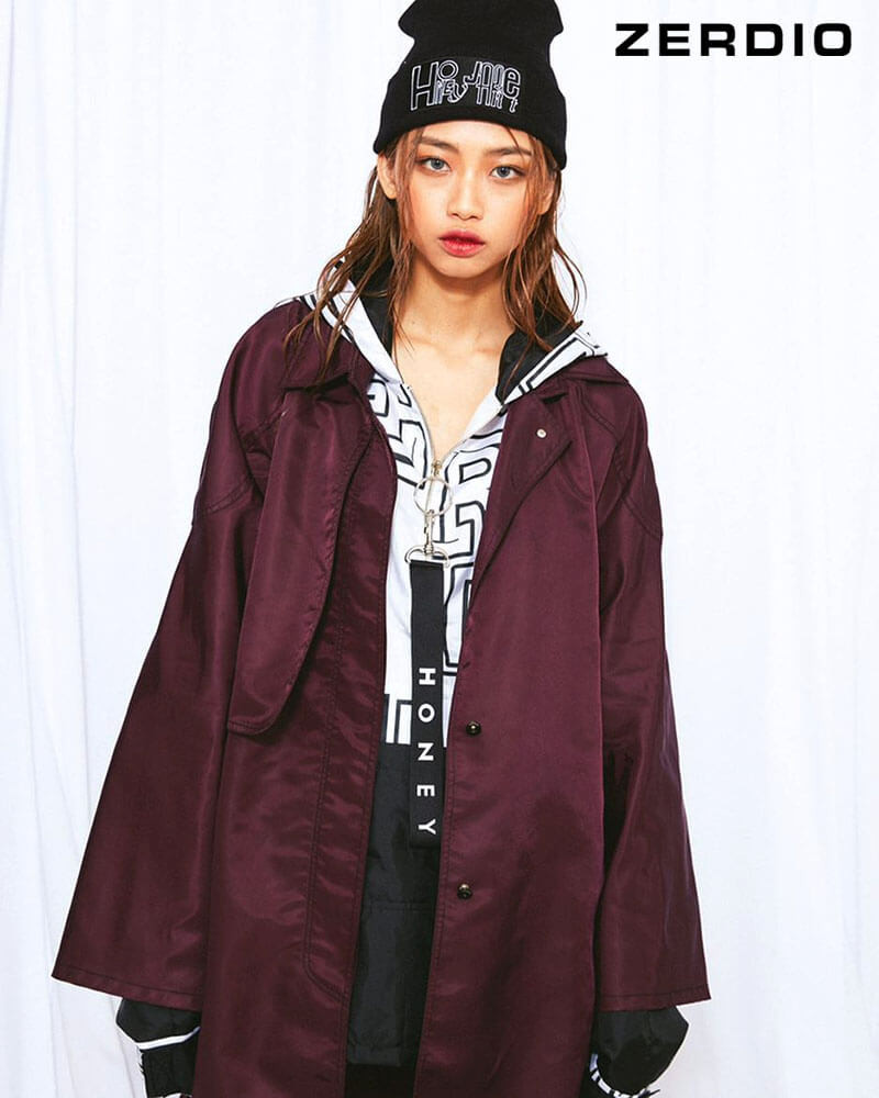 Cô gái trẻ diện trang phục hiphop mùa đông ấm áp với áo khoác phao, quần jeans và mũ len beanie màu đen, thể hiện gu thời trang cá tính.