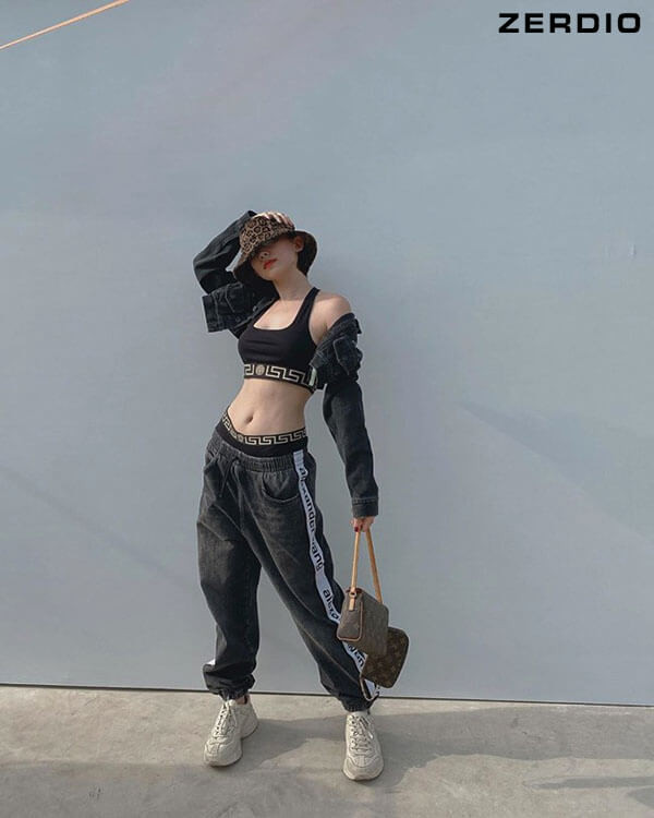 Cô gái trẻ trung phối áo croptop trắng cùng quần thể thao kẻ sọc hồng và mũ bucket, toát lên vẻ ngoài hiphop năng động.