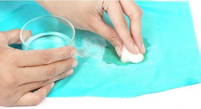 Dùng bông gòn thấm acetone để tẩy vết mực trên bề mặt quần áo