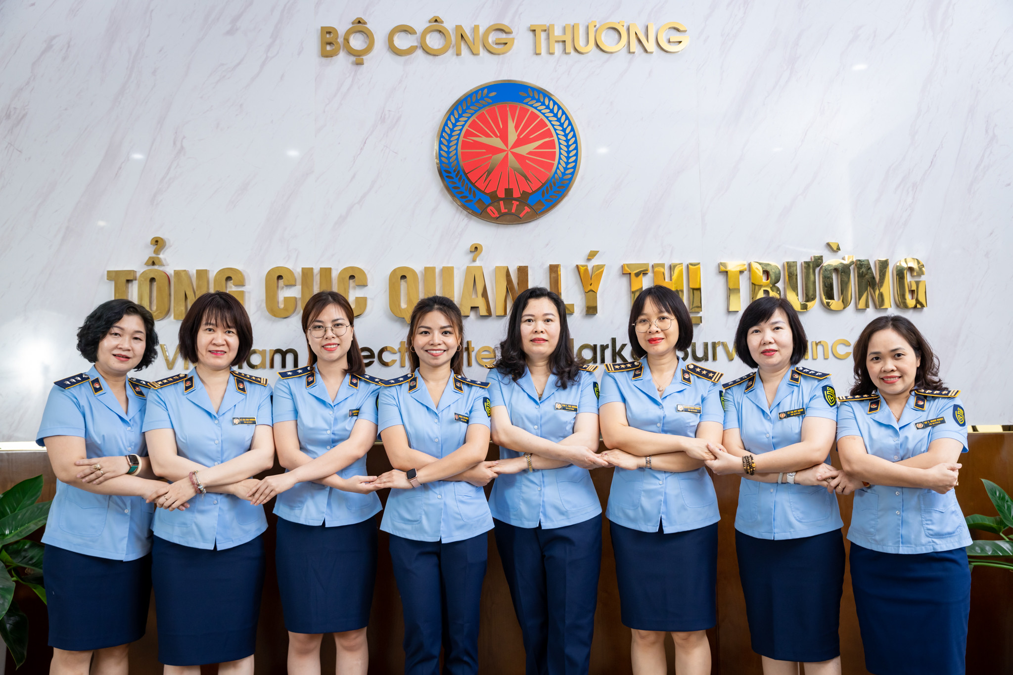 Lực lượng cán bộ quản lý thị trường mặc áo công vụ, tập trung tại một buổi lễ tuyên dương hoặc kỷ niệm