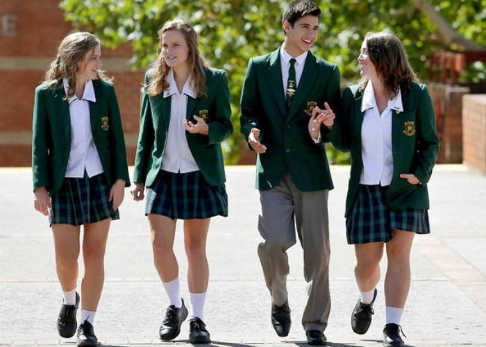 Mẫu đồng phục quần tây áo trắng học sinh Tây Ban Nha với áo sơ mi dáng thụng và quần tây xám, chân váy xếp ly ngắn