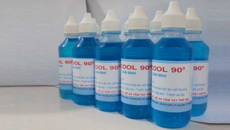 Người phụ nữ đang thấm cồn 90 độ lên vết mực trên quần áo để tẩy rửa