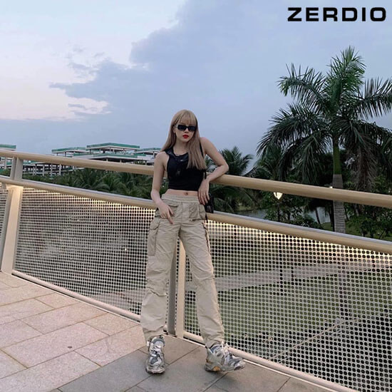 Nữ ca sĩ với quần jogger túi hộp màu xanh rêu, áo phông đen in chữ và giày sneaker, minh họa cách phối đồ hiphop nữ với quần jogger.