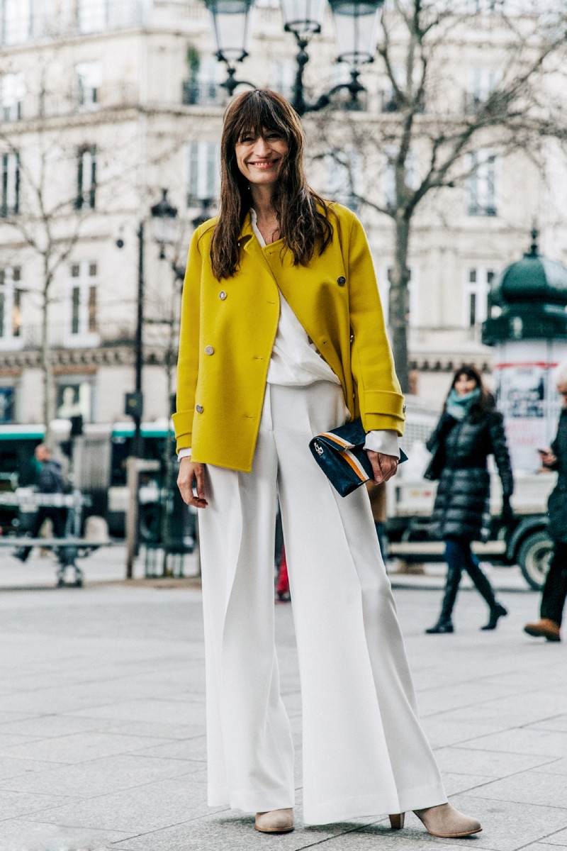 Quần ống rộng màu trắng phối áo len vàng nhạt, tạo vẻ ngoài thanh lịch và hiện đại cho cô gái