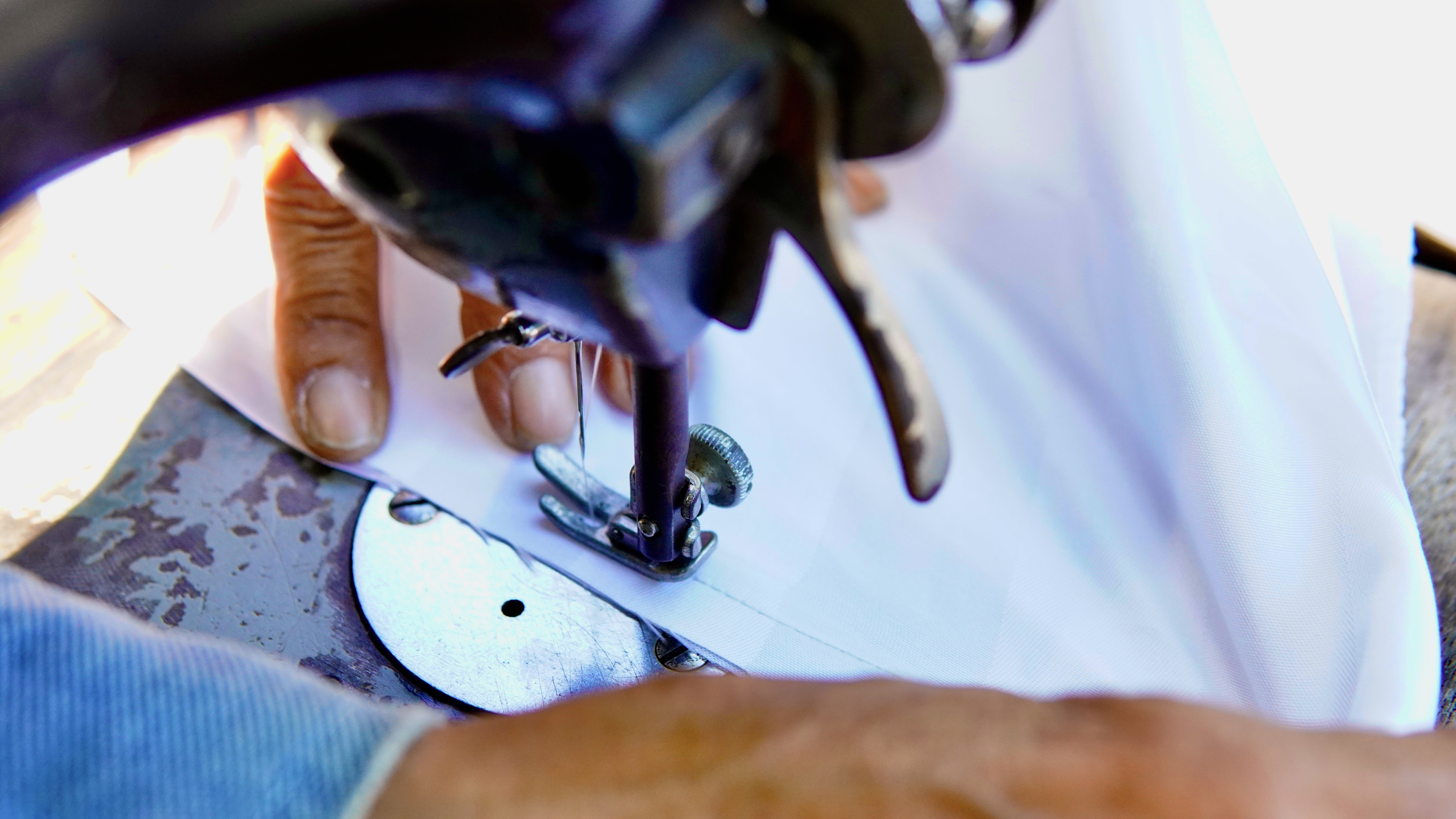 Thợ may đang khéo léo điều chỉnh đường may trên máy may để đảm bảo chất lượng sửa quần áo Nha Trang